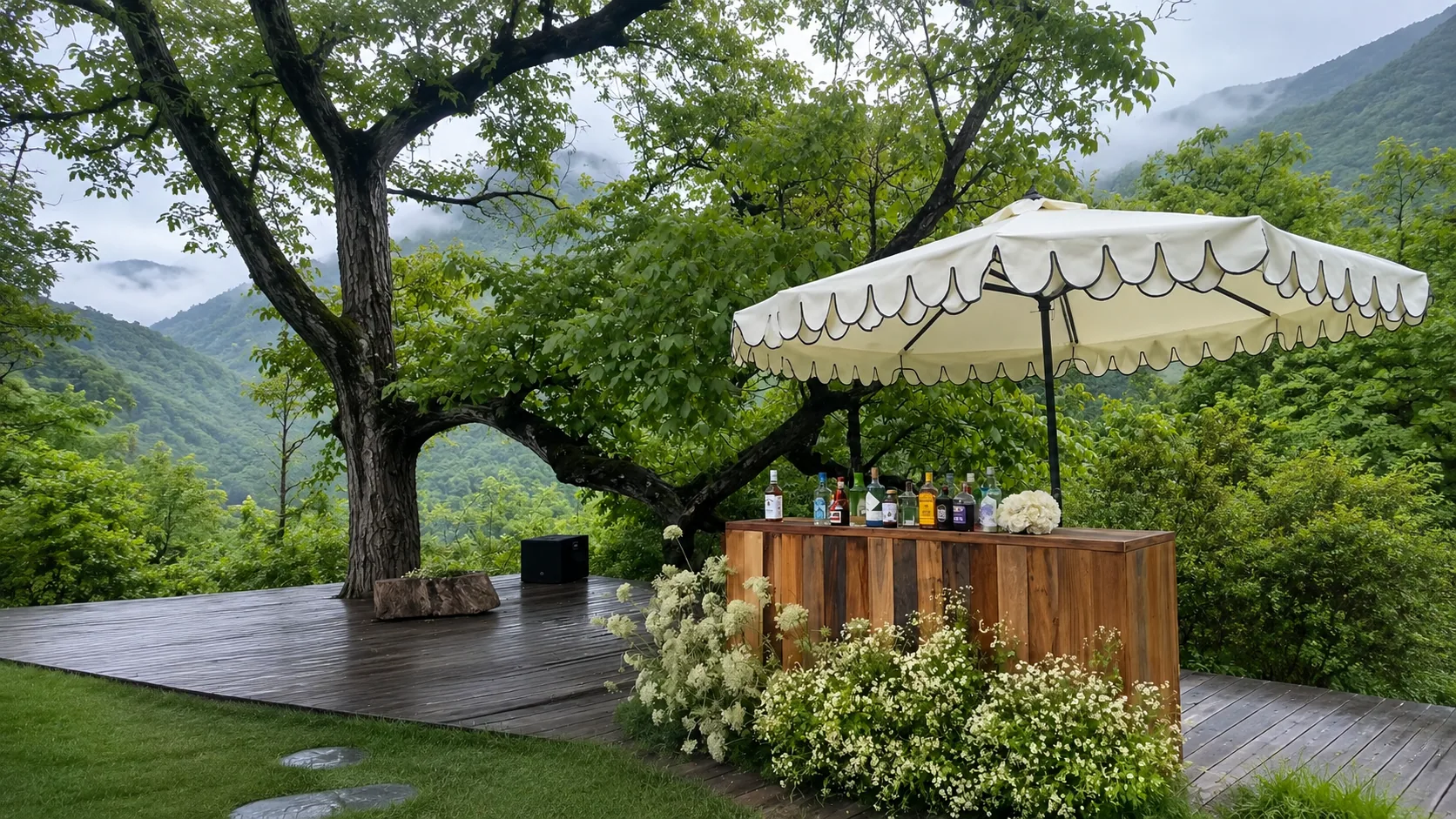 Ivory scalloped umbrella above a wooden garden bar surrounded by trees and white flowers