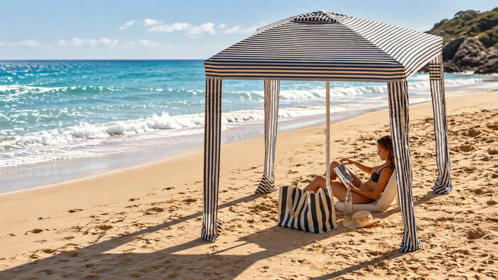 Blue and white cabana on a sunlit beach with a reader resting in the shade
