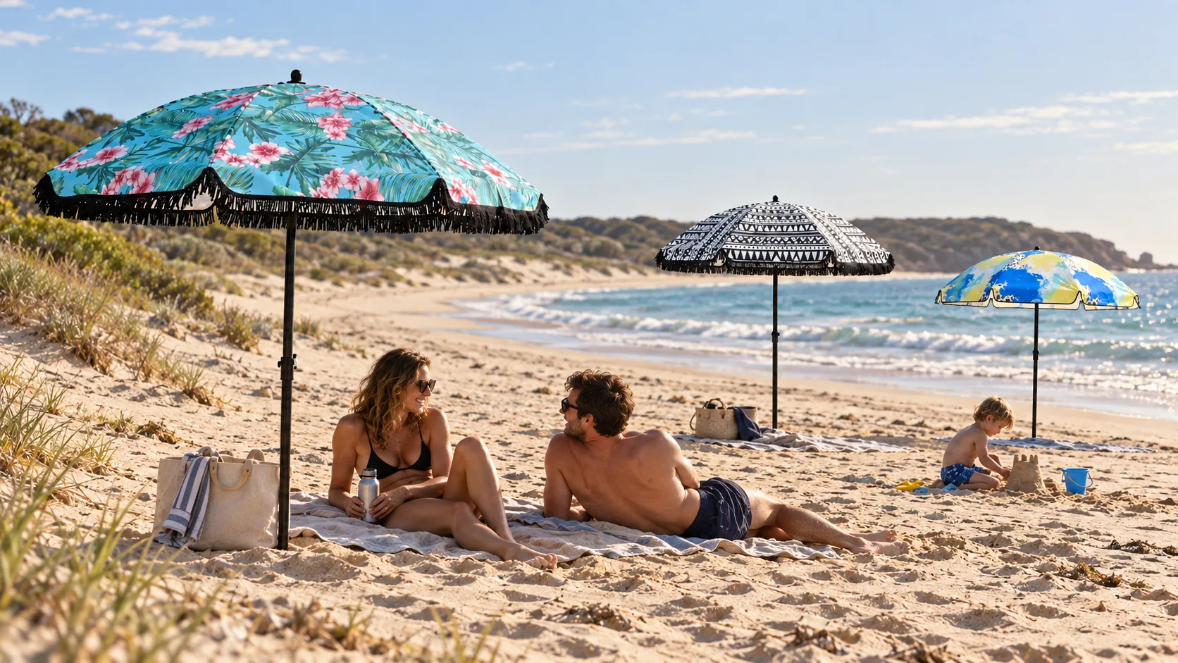 Three printed umbrellas in a family coastal scene