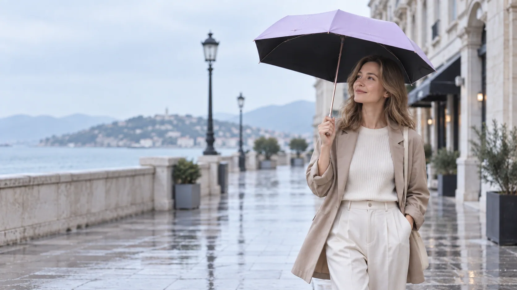 A woman carrying a lavender pencil umbrella along a rain-damp city street
