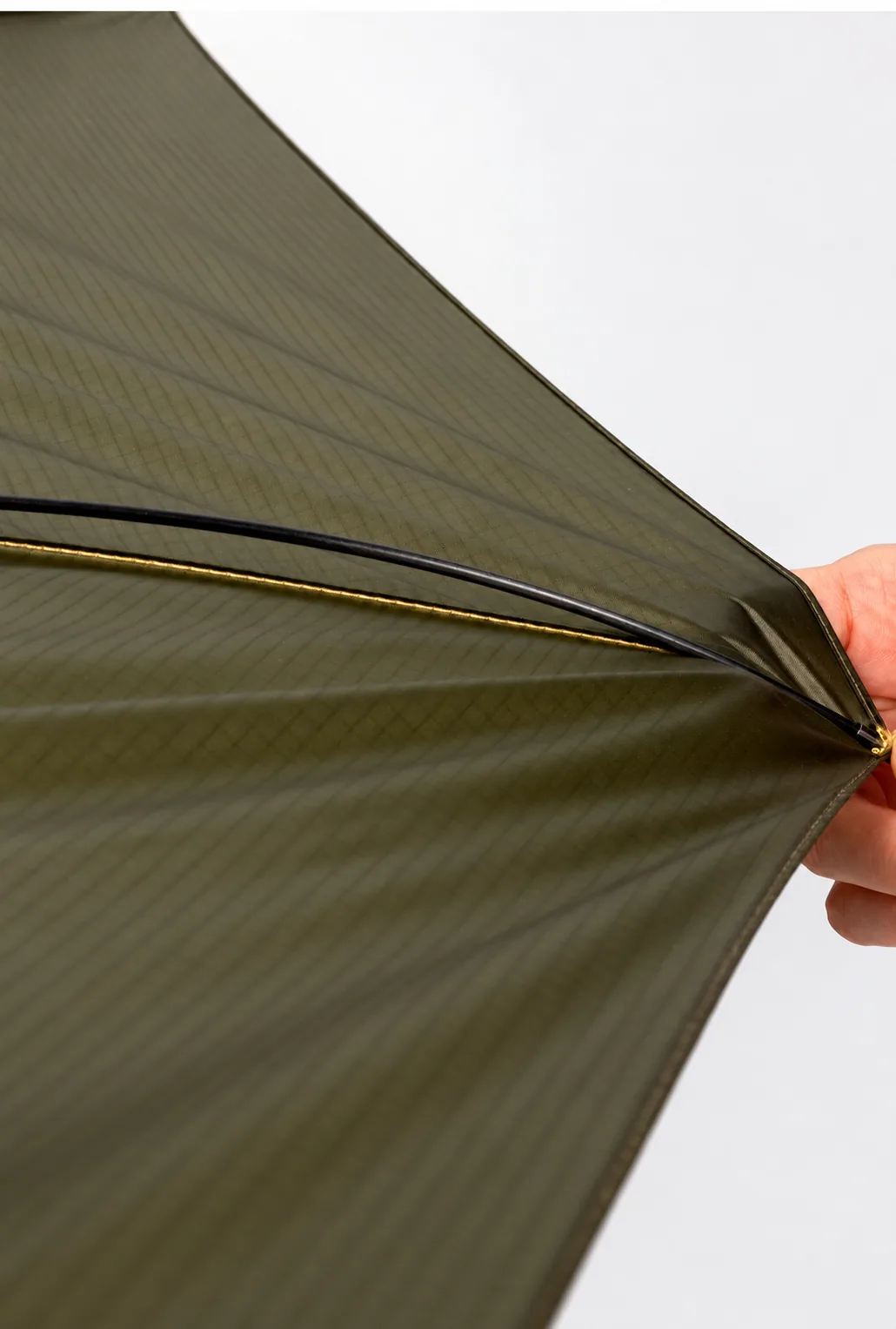 Carbon-fibre rib beneath the olive ripstop canopy